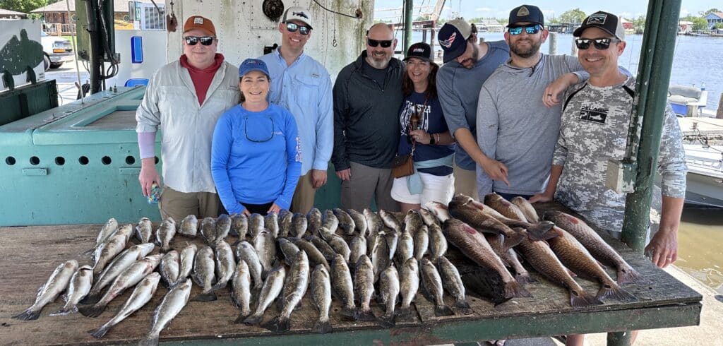 group of people after their first time fishing with their catch